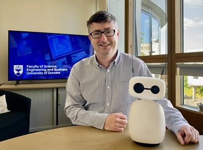 Dr Michael Crabb with his robot Baxter, which utilises AI to communicate with humans. Credit - University of Dundee.